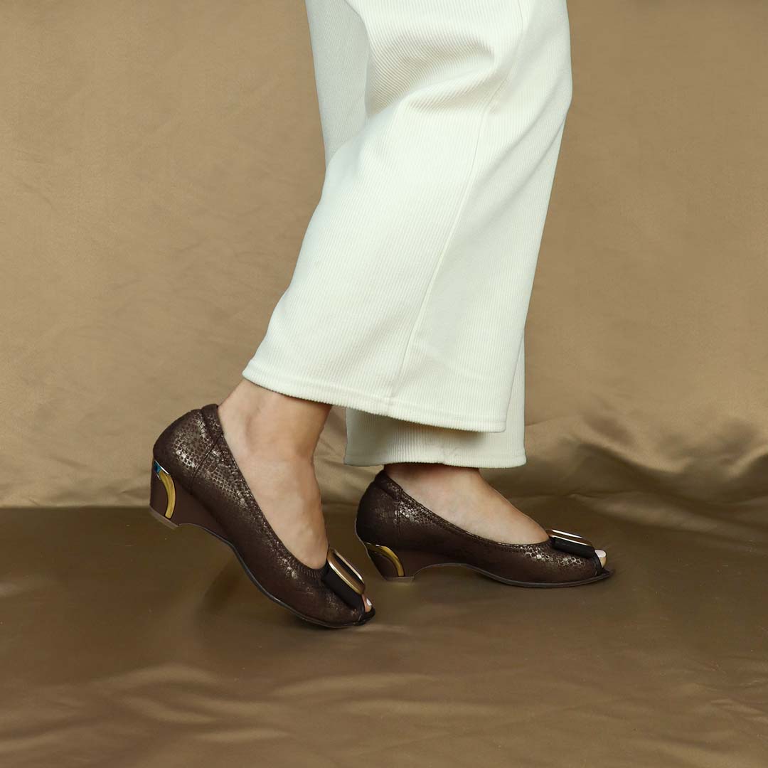 A model showcasing Thomas Chan's Vintage Print Pumps with Ribbon Buckle in coffee color, featuring an arch-support footbed, standing against a cream backdrop.