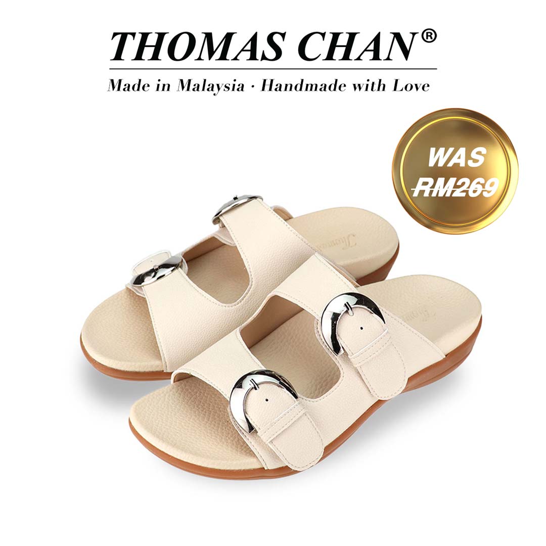 "Thomas Chan's Duo Buckle Slide-One flat sandals in ivory, featuring an elegant design with an arch-support footbed. The 'THOMAS CHAN®' brand is prominently displayed with 'Made in Malaysia · Handmade with Love' below. A gold and white banner highlights the special offer: 'Was RM269.' The sandals also feature an adjustable strap.