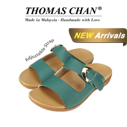 Thomas Chan's Great Coverage Buckle Flat Sandals in turquoise green, featuring an elegant design with an arch-support footbed. The 'THOMAS CHAN®' brand is prominently displayed with 'Made in Malaysia · Handmade with Love' below. A gold and white banner highlights the special offer: 'New Arrival.' The sandals also feature an adjustable strap.