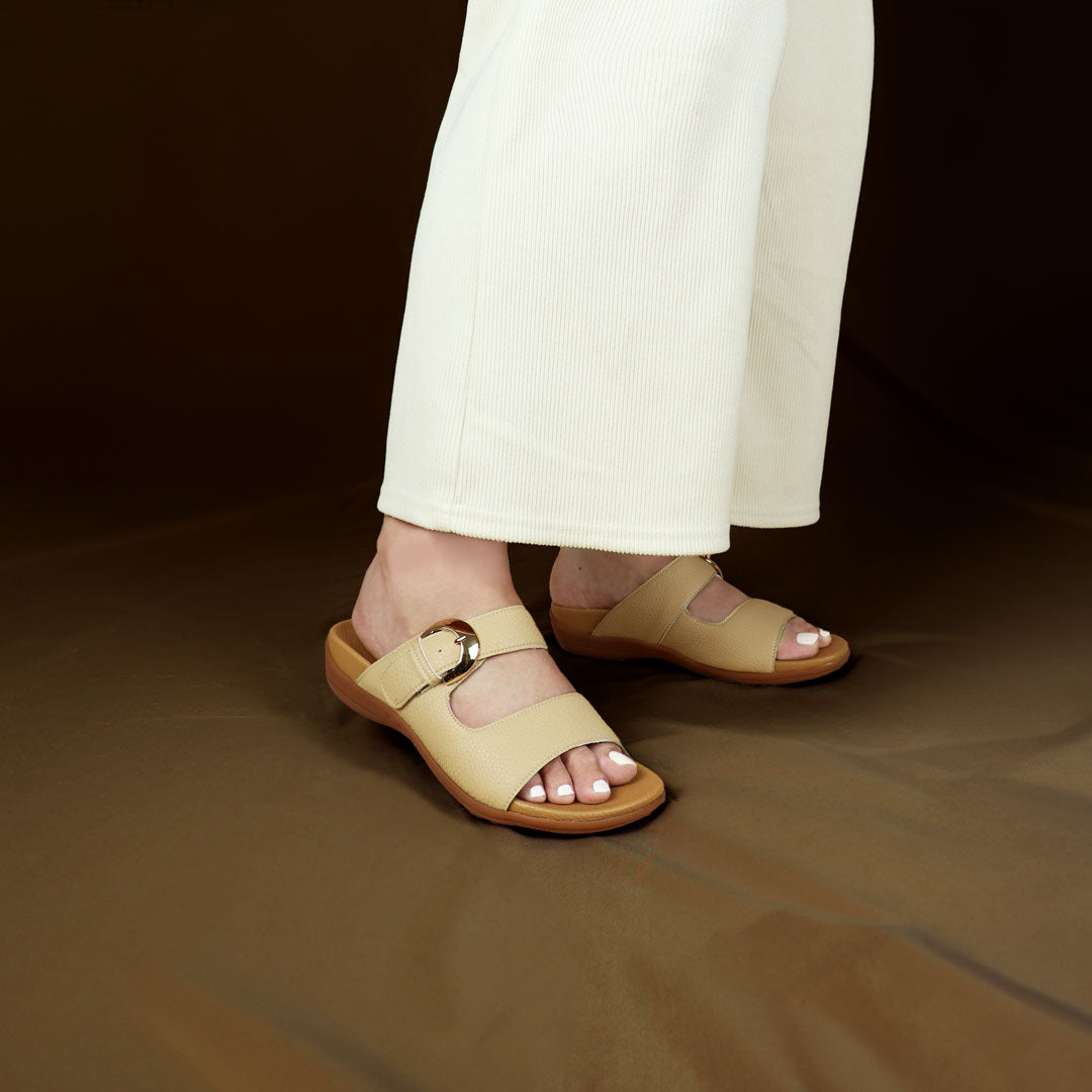 Model wearing size 37 Thomas Chan's Great Coverage Buckle flat sandals in mustard cream from the front view, standing. The sandals feature a comfort footbed with a 3cm flat platform. Behind the model is a bronze-coloured backdrop.