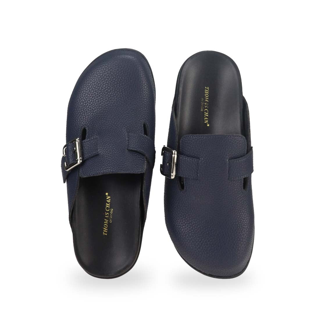 Front view of Thomas Chan's closed-toe buckle sandals in blue colour with pebbled texture, the sandals feature a sleek design with a silver buckle strap across the top and a black inner lining, with arch-support footbed.