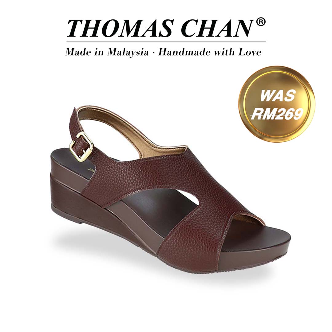 Thomas Chan Daily Wear Slingback Low Wedges in cocoa brown, featuring pebbly lychee print, elegant slingback design and arch-support footbed. "THOMAS CHAN®" brand displayed with "Made in Malaysia · Handmade with Love" below. Gold and white banner highlights special offer: "Was RM269"