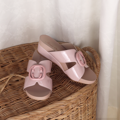 The image shows Thomas Chan soft pastel pink casual deco cutout low wedge sandals placed on a rattan element, presenting an elegant and chill style. The brand indicates it's from Thomas Chan Malaysia. A cream curtain in the background enhances the aesthetic.