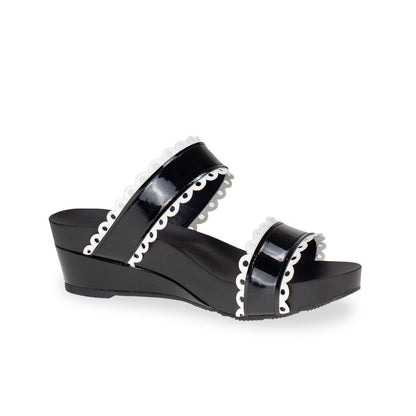 diagonal view of comfortable cute Thomas Chan handmade slide sandals in black and white flower cutout strappy design