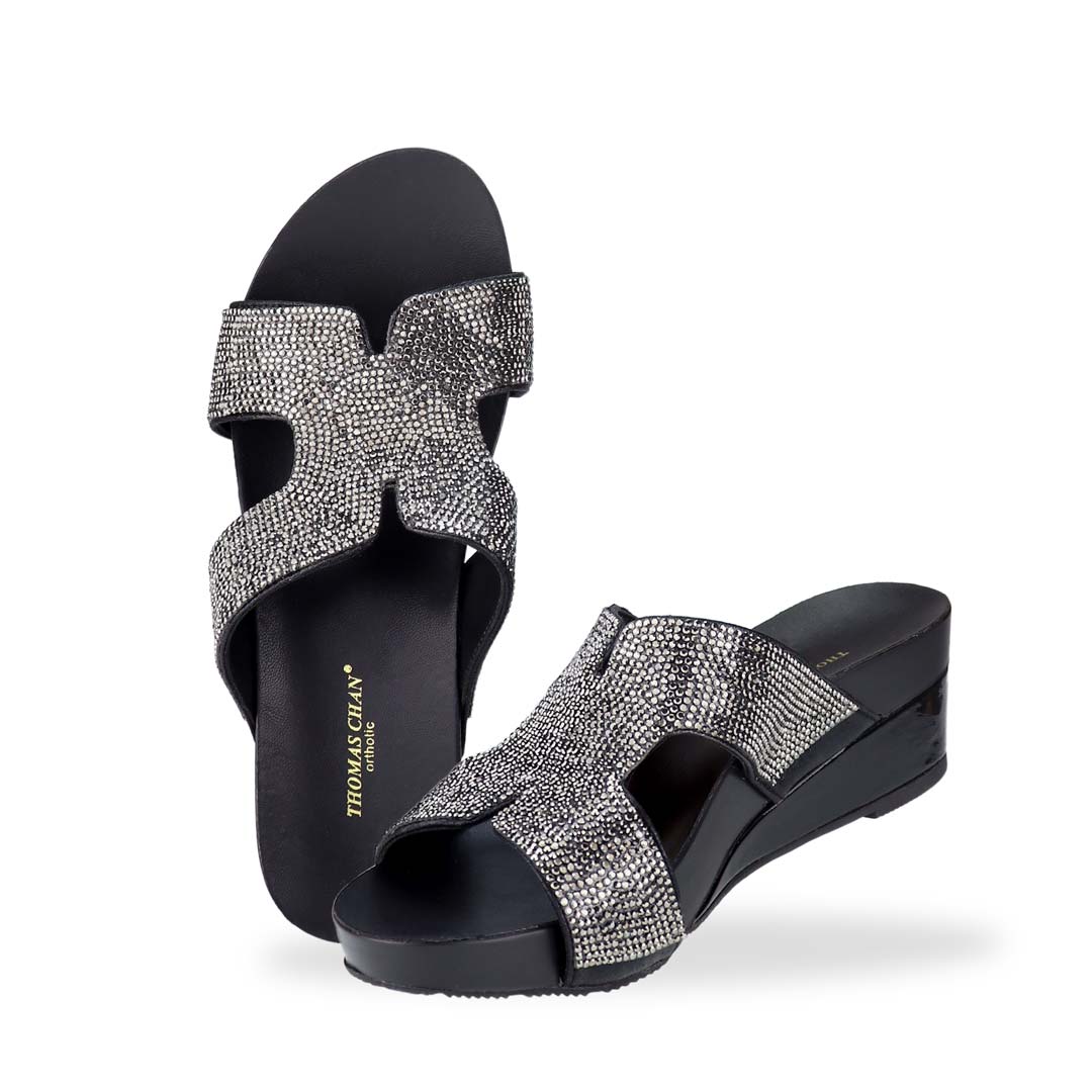 Full view of Thomas Chan's H-strap Glamour Stone Low Wedges in black, adorned with glamour rhinestone detailing ,and an arch-support footbed.