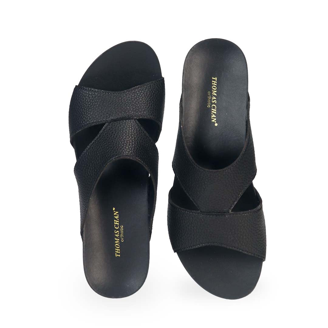 Front view of Thomas Chan's Pebble Lychee Everyday Low Wedge Slides in black, featuring an arch-support footbed. 