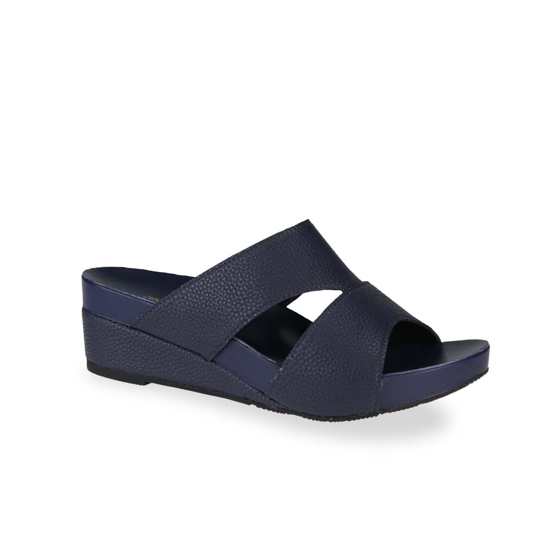 Diagonal view of Thomas Chan's Pebble Lychee Everyday Low Wedge Slides in dark blue, featuring an arch-support footbed. 