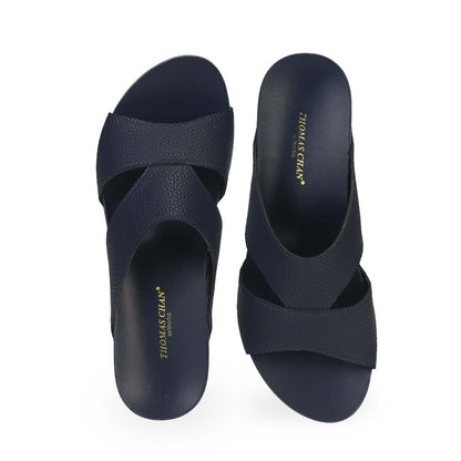 Front view of Thomas Chan's Pebble Lychee Everyday Low Wedge Slides in dark blue, featuring an arch-support footbed. 