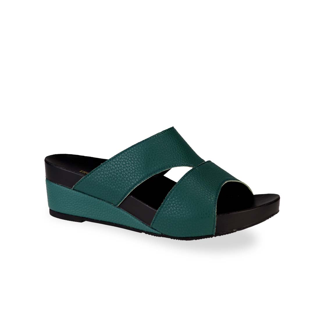 Diagonal view of Thomas Chan's Pebble Lychee Everyday Low Wedge Slides in dark green, featuring an arch-support footbed. 