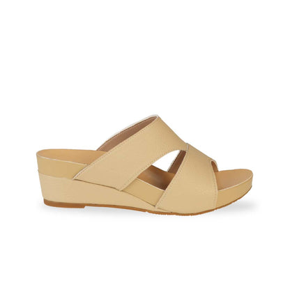 Side view of Thomas Chan's Pebble Lychee Everyday Low Wedge Slides in mustard cream, featuring an arch-support footbed. 