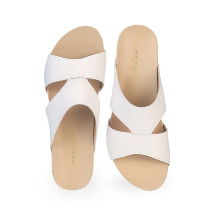 Front view of Thomas Chan's Pebble Lychee Everyday Low Wedge Slides in pastel white, featuring an arch-support footbed. 