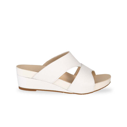 Side view of Thomas Chan's Pebble Lychee Everyday Low Wedge Slides in pastel white, featuring an arch-support footbed. 