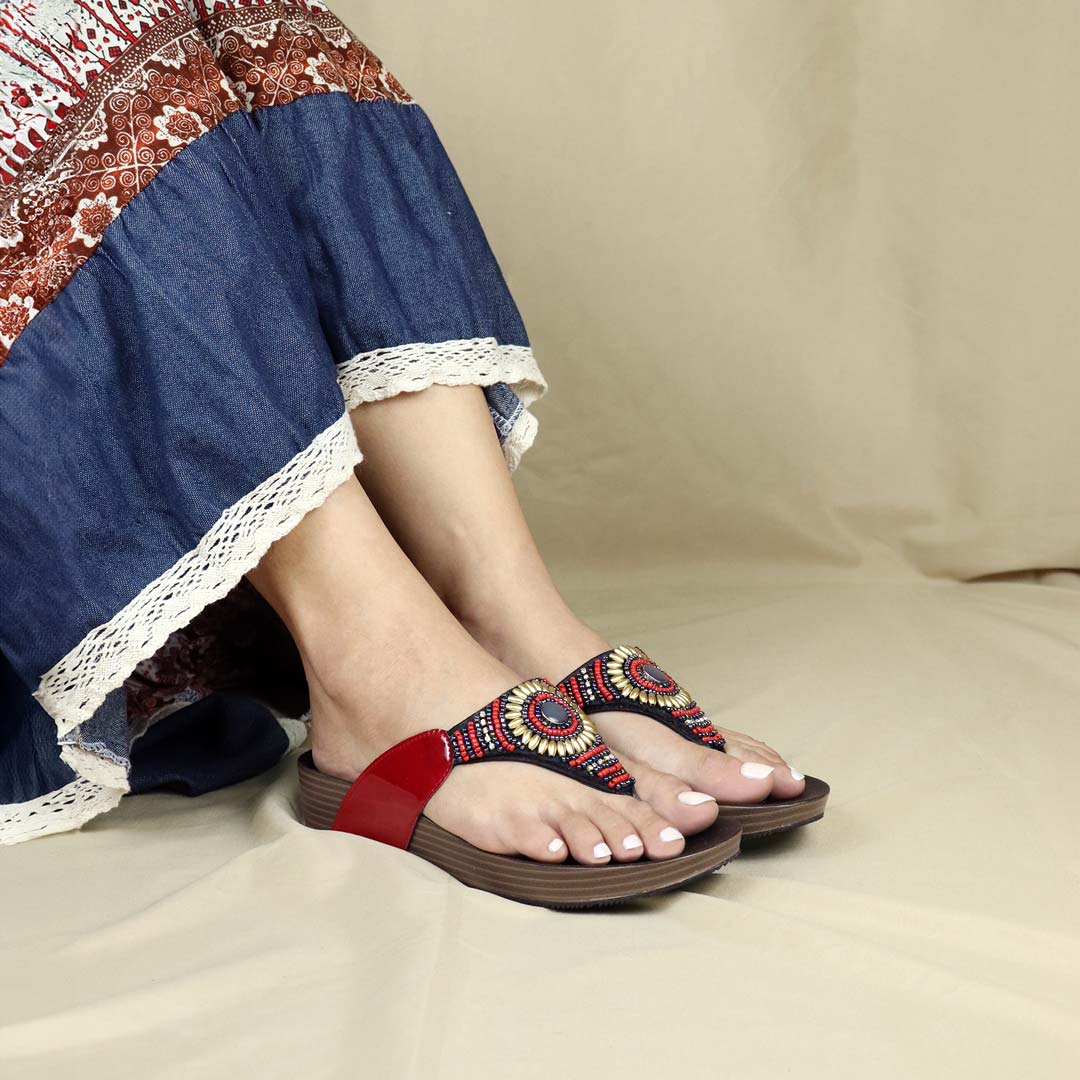 A model wearing red Thomas Chan's Boho Beaded Flatform Flip-Flops with a 3cm flatform, paired with ethnic dress. Set against a cream-colored backdrop, highlighting the flip-flops' boho beaded design and casual style.