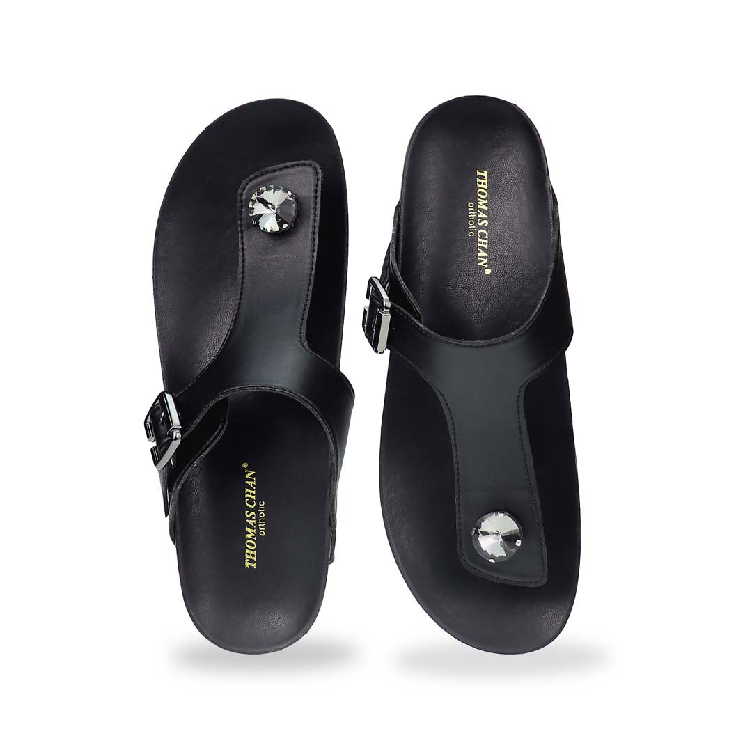 Front view of Thomas Chan’s Dazzle Crystal Adjustable Flip-Flops in black, featuring a sparkling crystal stone, adjustable buckle strap, and LiteStep flatform footbed, highlighting their casual yet elegant style.