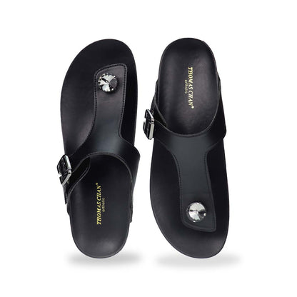 Front view of Thomas Chan’s Dazzle Crystal Adjustable Flip-Flops in black, featuring a sparkling crystal stone, adjustable buckle strap, and LiteStep flatform footbed, highlighting their casual yet elegant style.