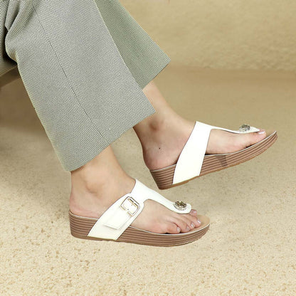 Side-angle view of Thomas Chan’s Dazzle Crystal Adjustable Flip-Flops in ivory, showcased by a model against a cream studio backdrop, highlighting the sparkling crystal stone, adjustable buckle strap, and LiteStep flatform footbed.