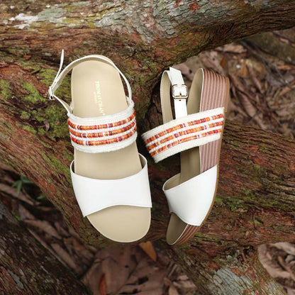 Full view of Thomas Chan’s Summer Love Duo-Strap Slingback Sandals in ivory with a subtle touch of orange, placed on a fallen wood surface. The image highlights the elegant duo straps, secure slingback design, and LiteStep flatform sole with light arch support, emphasizing their casual yet sophisticated style.