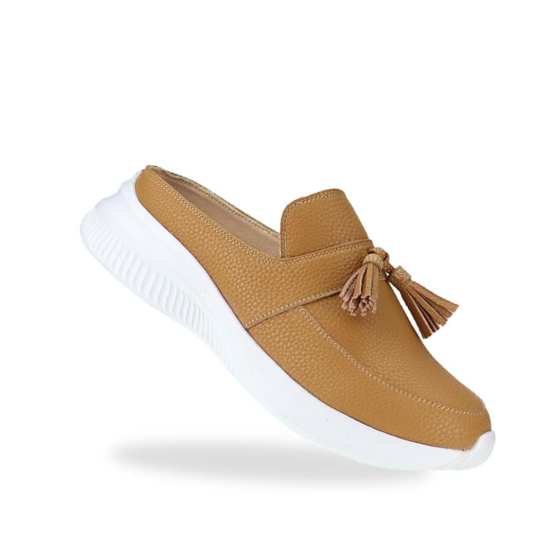 Diagonal view of Thomas Chan Feather-Light Tassel Slide-On Loafers in camel, featuring a tassel bell design and a comfortable cushioned footbed.