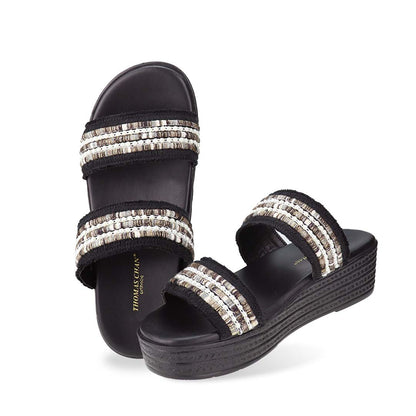 Full view of Thomas Chan Summer Love Boho low platform sandals in black and little white embroidery, featuring a comfort footbed. The platform, with a black braided element, measures 3cm at the front and 5cm at the back.