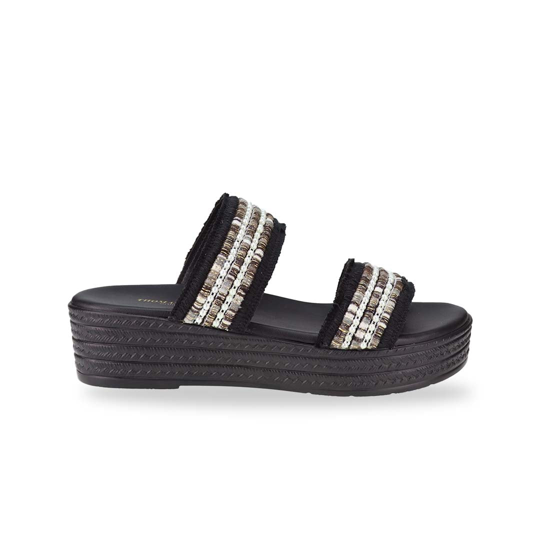 Side view of Thomas Chan Summer Love Boho low platform sandals in black and little white embroidery, featuring a comfort footbed. The platform, with a black braided element, measures 3cm at the front and 5cm at the back.