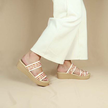 Model wearing size 37  Thomas Chan Summer Love Boho low platform sandals in orange and white embroidery from the side view, featuring a comfort footbed. The platform, with a light brown braided element, measures 3cm at the front and 5cm at the back.