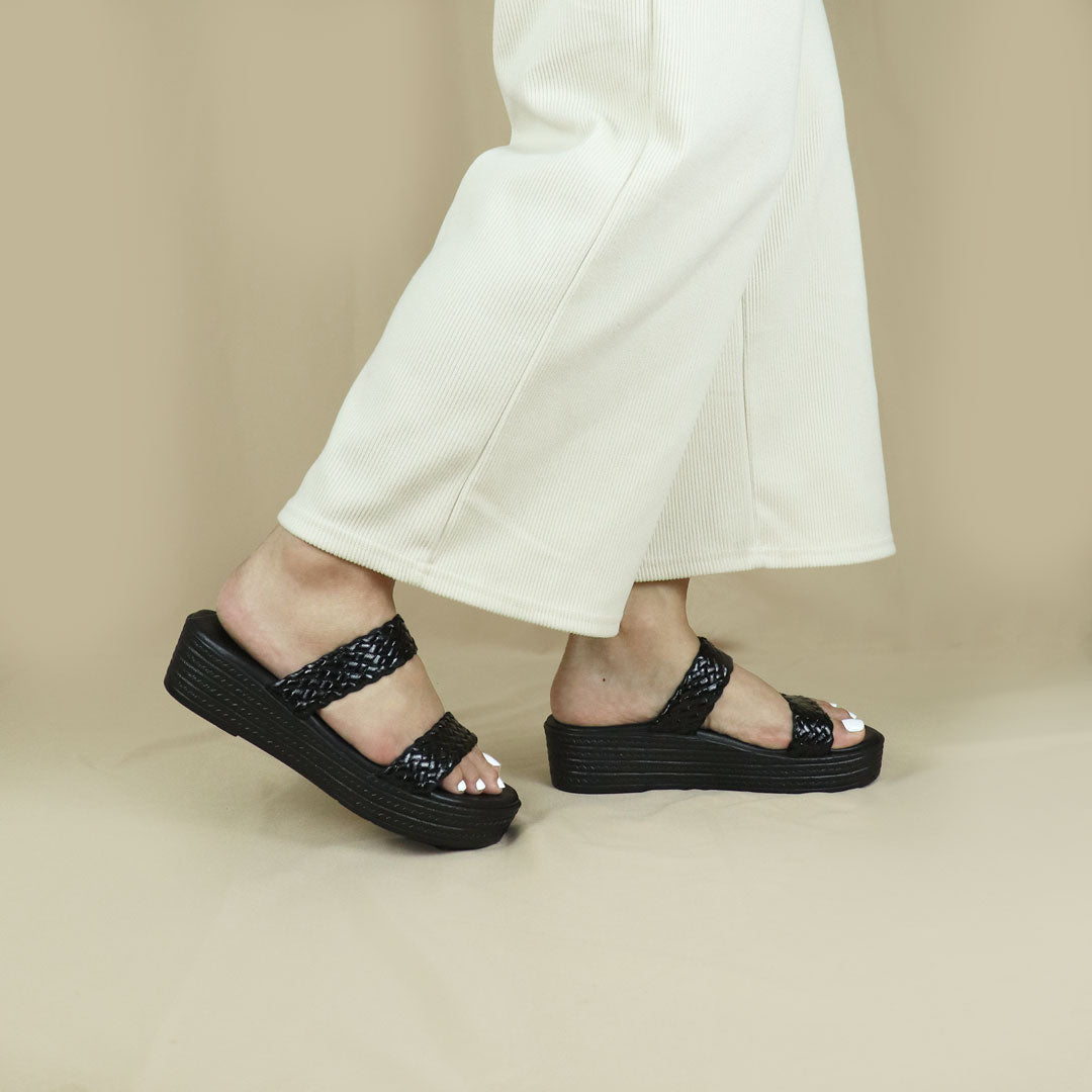 Model wearing size 37  Thomas Chan Pretty Essential Strappy Flatform sandals in black from the standing side view, featuring a comfort footbed. The platform, with a black braided element, measures 3cm at the front and 5cm at the back.