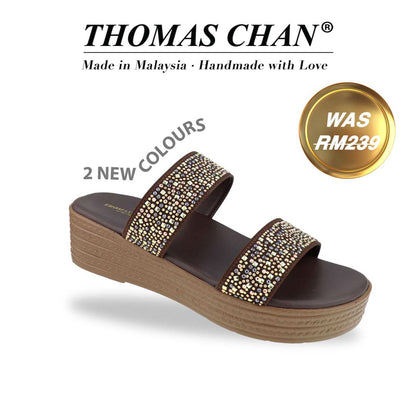 Diagonal view of the Thomas Chan Strappy Rhinestone Flatform Sandals in brown, featuring two elegant rhinestone-adorned straps and a cushioned footbed designed for maximum comfort. The 'THOMAS CHAN®' brand logo is clearly visible, with the inscription 'Made in Malaysia · Handmade with Love' underneath. A gold and white banner showcases the special offer: 'Was RM239.' & '2 NEW COLOURS'.