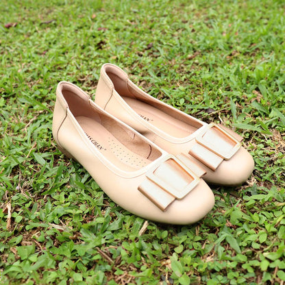 The cream colour Thomas Chan's Soft Calf Leather Ribbon Ballet Pumps arranged on lush green grass, with natural lighting enhancing their texture and details.