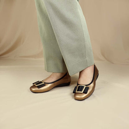 A model wearing the bronze colour Thomas Chan's Soft Calf Leather Ribbon Ballet Pumps in a studio setting, paired with office attire, demonstrating their elegant and professional appearance.