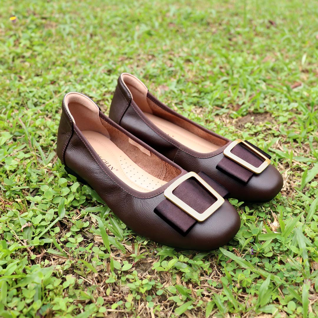 The dark brown colour Thomas Chan's Soft Calf Leather Ribbon Ballet Pumps arranged on lush green grass, with natural lighting enhancing their texture and details.