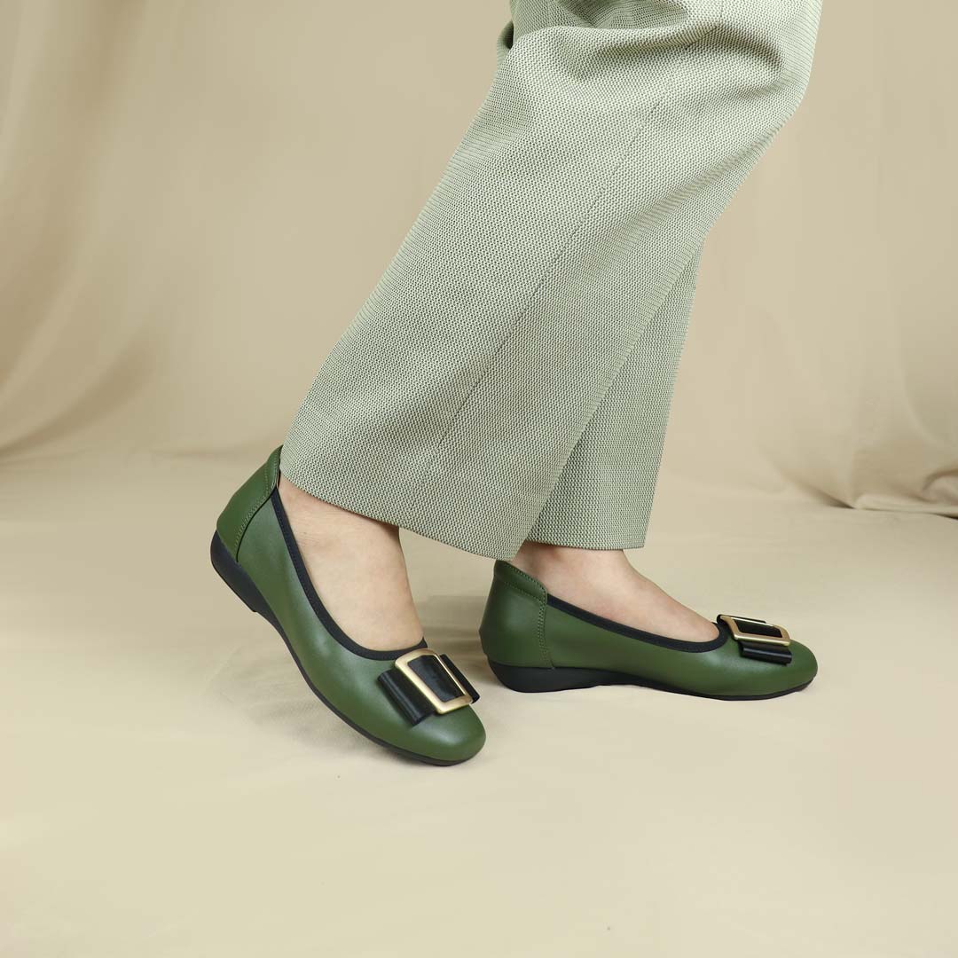 A model wearing the deep green colour Thomas Chan's Soft Calf Leather Ribbon Ballet Pumps in a studio setting, paired with office attire, demonstrating their elegant and professional appearance.