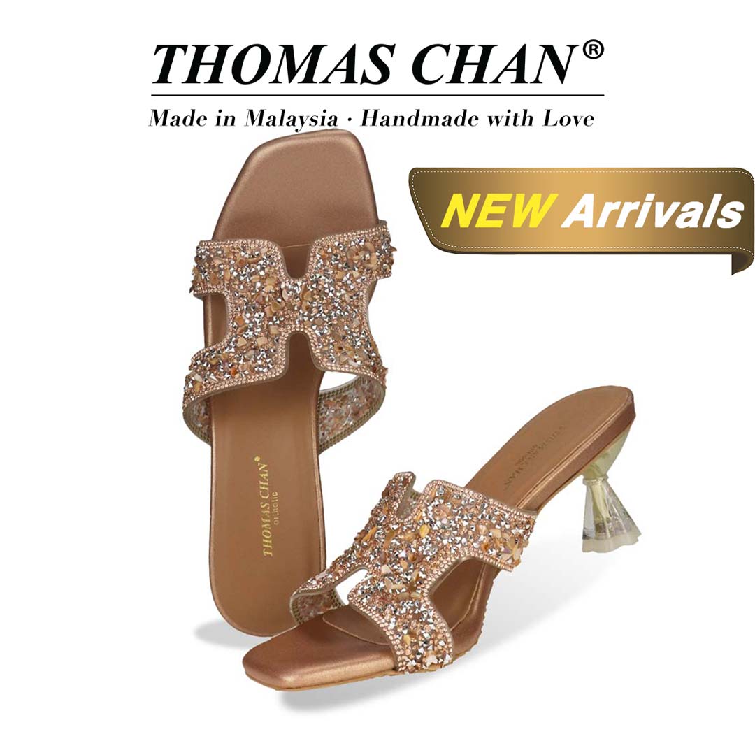 Thomas Chan's Sparkle Jewel H-Strap Heeled Sandals in bronze colour, featuring an elegant design and a uniquely designed heel. "THOMAS CHAN®" brand displayed with "Made in Malaysia · Handmade with Love" below. Gold and white banner highlights special offer: "New Arrival."