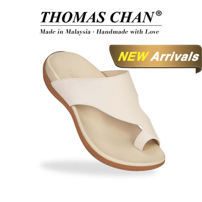 Thomas Chan's Simple Toe Strap Flat Sandals in ivory, displaying an elegant design with an arch-support footbed. "THOMAS CHAN®" brand prominently shown with "Made in Malaysia · Handmade with Love" below. Gold and white banner highlights special offer: "New Arrival."