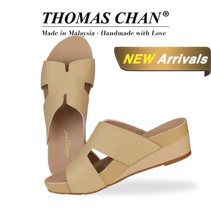 Thomas Chan Pebble Lychee H-Strap Low Wedge Slides in rosy mustard cream, featuring an arch-support footbed. The "THOMAS CHAN®" brand is displayed with "Made in Malaysia · Handmade with Love" below. A gold and white banner highlights a special offer: "New Arrival."