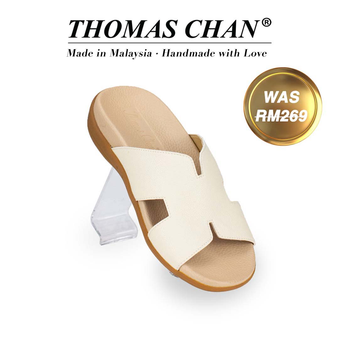 Thomas Chan's Best Seller Extra Comfort H-Strap Flats in Ivory White, displaying an elegant design with an arch-support footbed. "THOMAS CHAN®" brand prominently shown with "Made in Malaysia · Handmade with Love" below. Gold and white banner highlights special offer: "WAS 269."