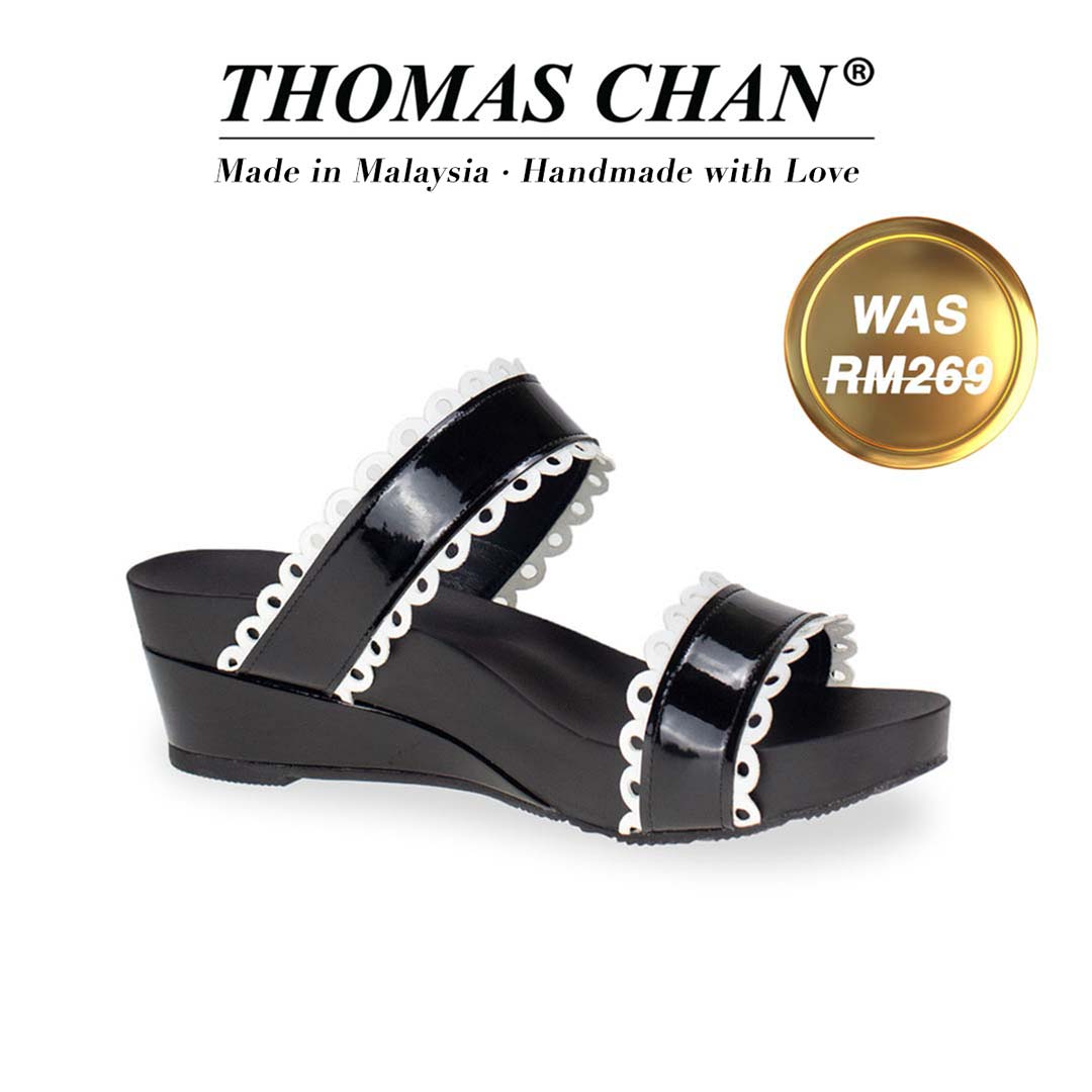 Thomas Chan's Flower Strappy Sandals in patent black with white flower stripe, featuring an elegant design and arch-support footbed. "THOMAS CHAN®" brand displayed with "Made in Malaysia · Handmade with Love" below. Gold and white banner highlights special offer: "WAS 269."