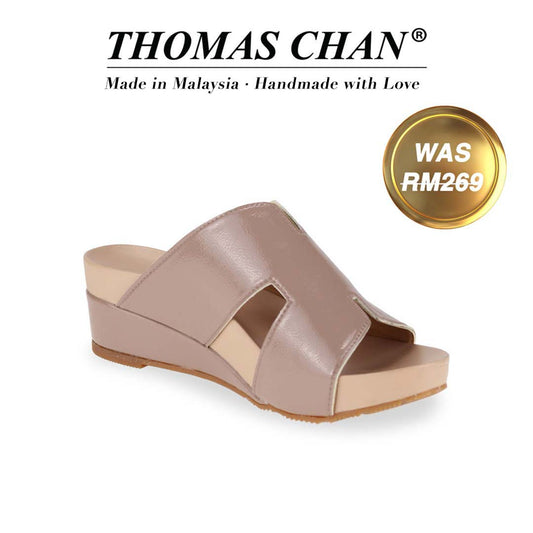 Introducing Thomas Chan's best-selling H-Strap Low Wedge Slides in light taupe, featuring a charming patent leather H-strap design and a 2-inch wedge heel. Designed with built-in arch-support footbed technology for enduring comfort, these sandals are as stylish as they are supportive. A gold badge proudly displays the original price of RM 269, complemented by text celebrating "THOMAS CHAN® Made in Malaysia · Handmade with Love."