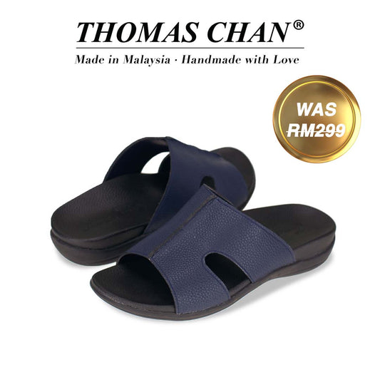 An image of Thomas Chan's Men Ultra-Comfort Cutout Slide Sandals in blue colour, featuring an arch-support footbed. The top of the image displays the brand name "THOMAS CHAN®" with the text "Made in Malaysia · Handmade with Love" below it. A gold and white banner on the right side states "WAS 299."